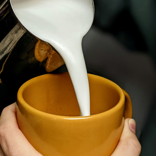 Pouring the milk into a mug (image source:https://www.pexels.com/photo/close-up-of-person-pouring-frothed-milk-into-a-mug-12240410/) <br><audio controls src='/audio/Pour milk.m4a'></audio>